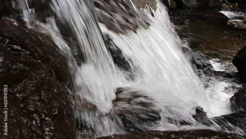 The view of the waterfall with rocks and clear water