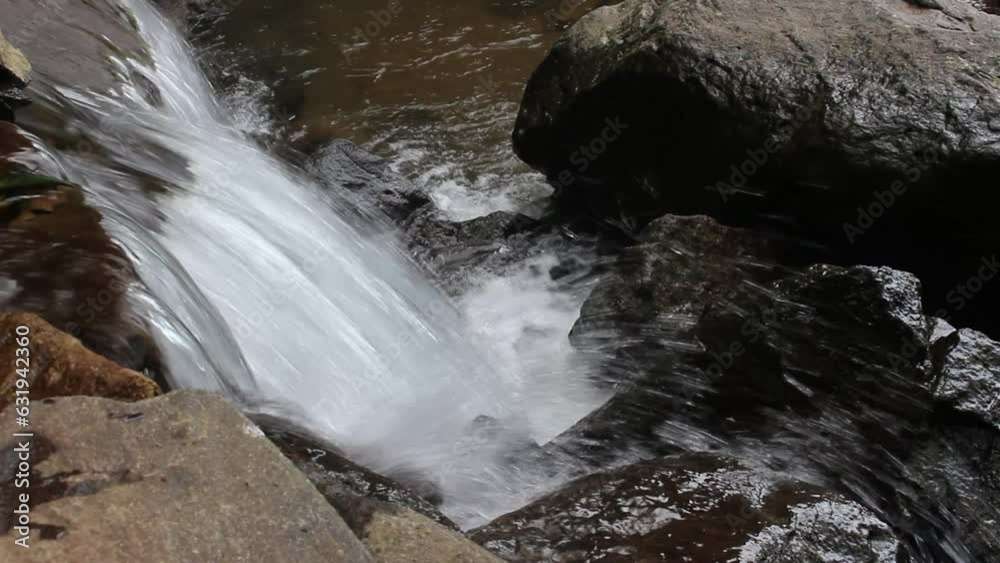 The view of the waterfall with rocks and clear water The view of the waterfall with rocks and clear water