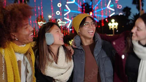 Group of diverse friends celebrating new year in the illuminated city with winter clothes
