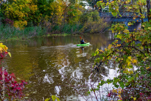 Kayaker Paddling On The River In Fall Color