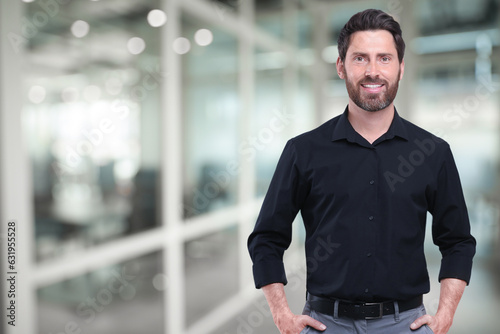 Portrait of handsome confident man in office, space for text
