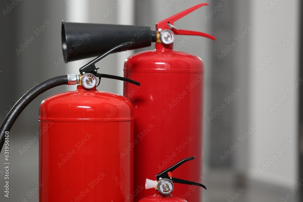 Obraz premium Three red fire extinguishers in hall, closeup