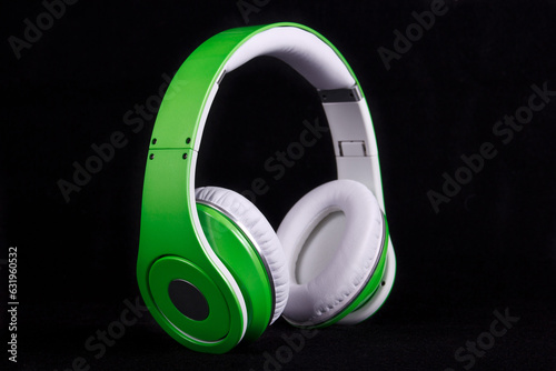 Stylish modern green headphones on black background.