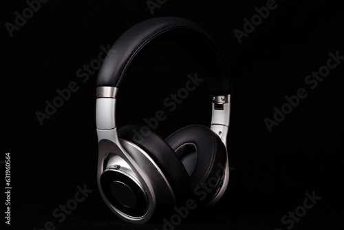 Stylish modern black and silver headphones on black background.