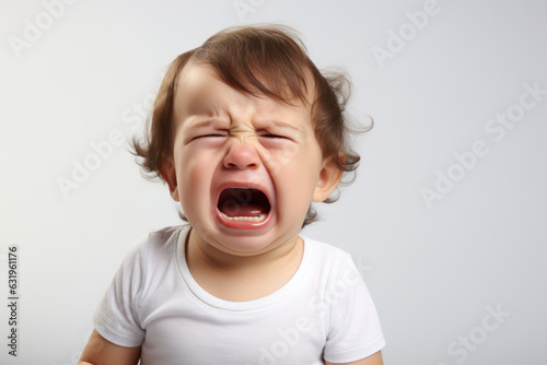 Closeup photo of a cute little baby boy child crying and screaming isolated on white background.