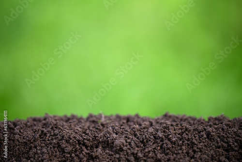 fertile pile of soil with green grass blurred background