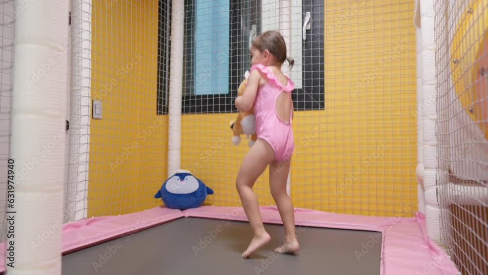 Smiling cheerful toddler girl jumping on trampoline at indoor playground - Slow motion Smiling cheerful toddler girl jumping on trampoline at indoor playground - Slow motion