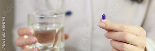 Female doctor shows one pill in her hand close-up.