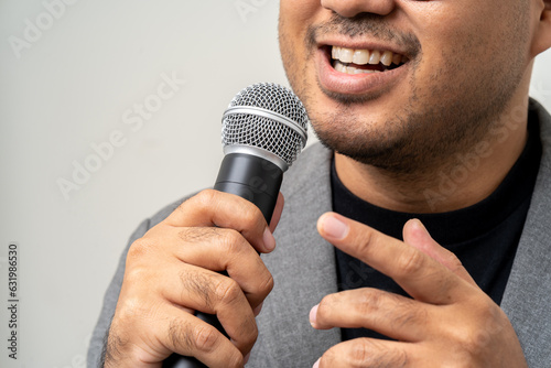 Close up businessman speaker hand holding High quality dynamic microphone and singing song or speaking talking with people on isolated white background. Male testing microphone voice for interview