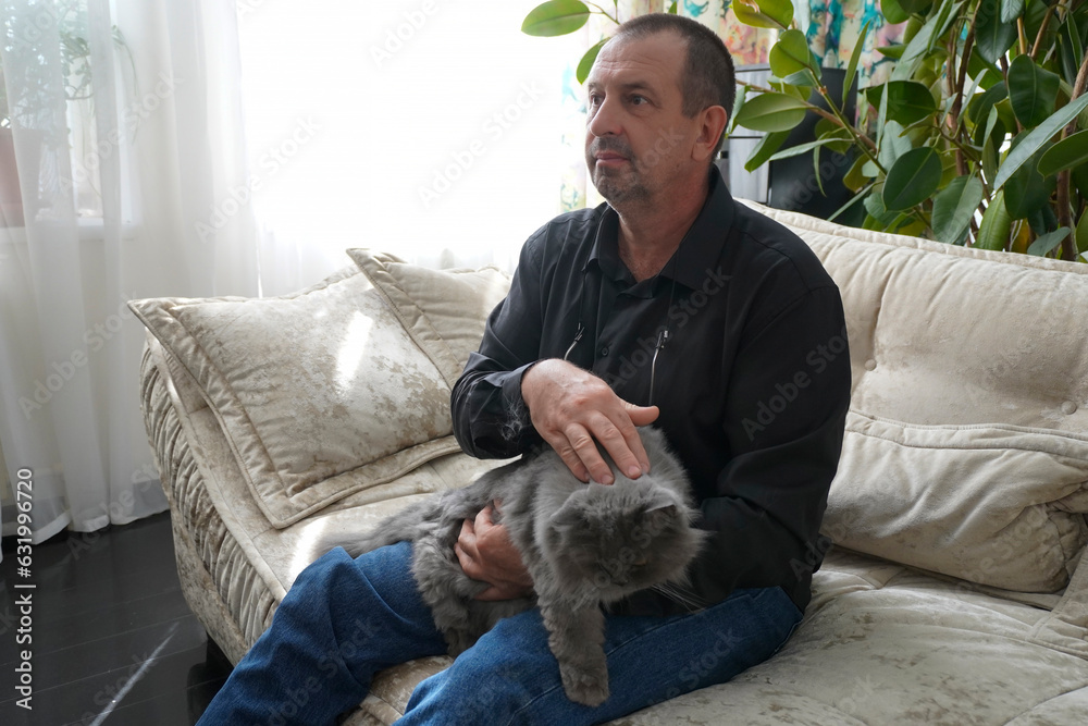 man sitting on sofa with cat
