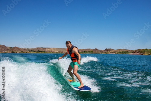 a man on a surfboard. a guy on a wave on a wakeboard © Наталья Удалова