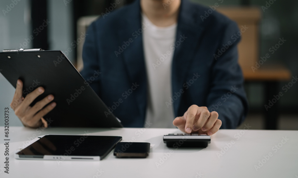 Business and financial concepts about office work. male are using calculators to calculate office income. Business and financial concepts about office work. male are using calculators to calculate office income.