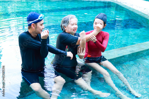 Fototapeta Naklejka Na Ścianę i Meble -  Elderly people doing physical therapy in water There are male and female staff doing physiotherapy for seniors. exercise for the elderly