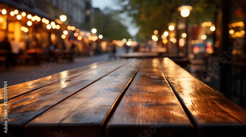 Empty wooden table outdoors. On a blurred background cafes and restaurants.