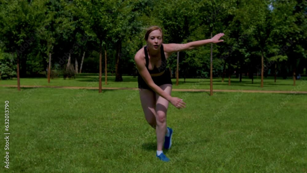 Active motivated charming fit middle aged woman in sportswear practicing skater lunges exercise on park green lawn, strengthening glute, hamstring, and inner thigh muscles during outdoor workout. Active motivated charming fit middle aged woman in sportswear practicing skater lunges exercise on park green lawn, strengthening glute, hamstring, and inner thigh muscles during outdoor workout.
