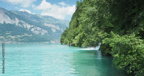 Majestic blue-green waters of the lake Brienz (Canton Bern)  with view on Giessbach cascade brooking into the lake seen from Giessbach landing stage photo