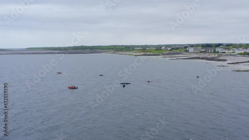 Drone orbit parallax around currach boat canoes in open ocean water of ireland photo