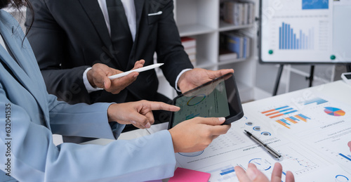 Business people meeting explaining the financial graph data and marketing plan on tablet. Group of business people at meeting assessment the state of business investment and marketing.