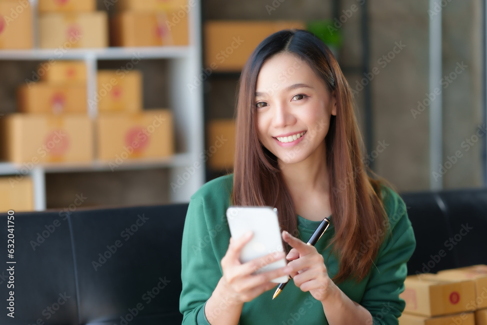 Beautiful Asian online business owner is using mobile phone checking with customer to check delivery address and phone number for accurate delivery. Beautiful Asian online business owner is using mobile phone checking with customer to check delivery address and phone number for accurate delivery.