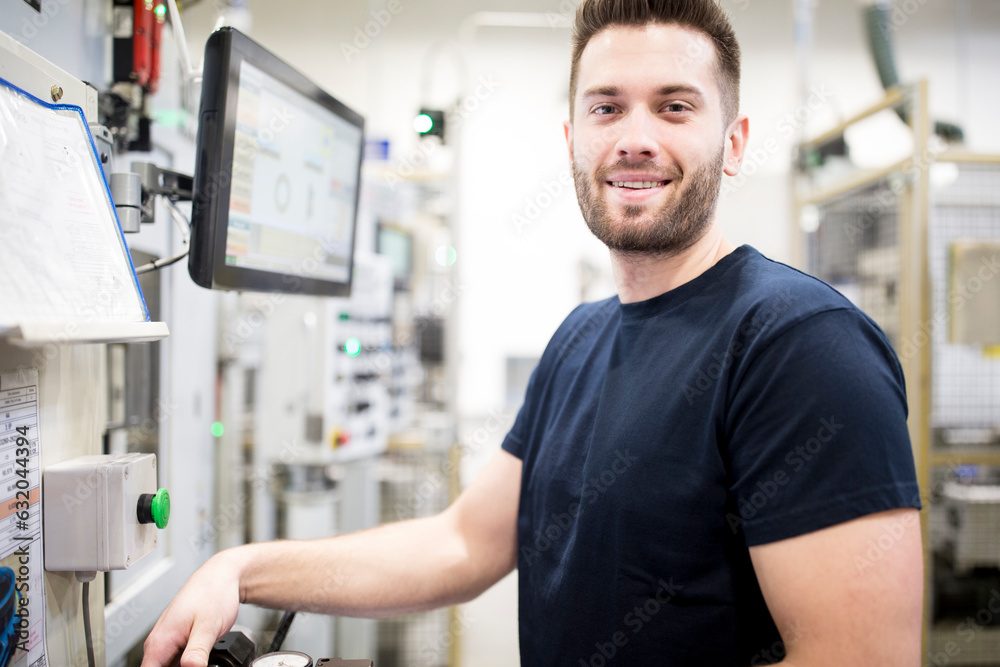 Portrait of a confident man working in a modern factory at a machine Portrait of a confident man working in a modern factory at a machine