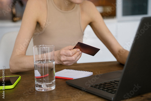 Freelancer using credit card for online payment on laptop at home photo