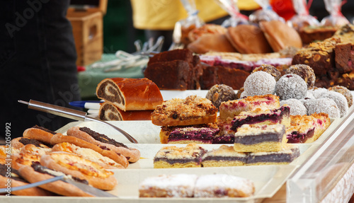 Bakery stand with variations of pastries, brownies, pies, cakes, and other desserts at strret food market in Prague. photo