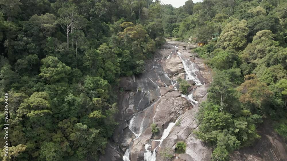 Aerial: Top of Air Terjun Waterfall on granite cliff face in Malaysia Aerial: Top of Air Terjun Waterfall on granite cliff face in Malaysia