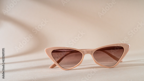 Trendy Sunglasses sale concept. Glamour cat eye frame sunglasses on beige background with shadows. Trendy Fashion summer accessory. Copy space. Eyewear sale, promotion. Optic store discount poster