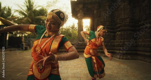 Slow Motion Portrait of Indian Women in Traditional Clothes Dancing Bharatanatyam in Colourful Sari . Close-up on Expressive Young Females Performing Folk Dance Choreography in an Ancient Temple
