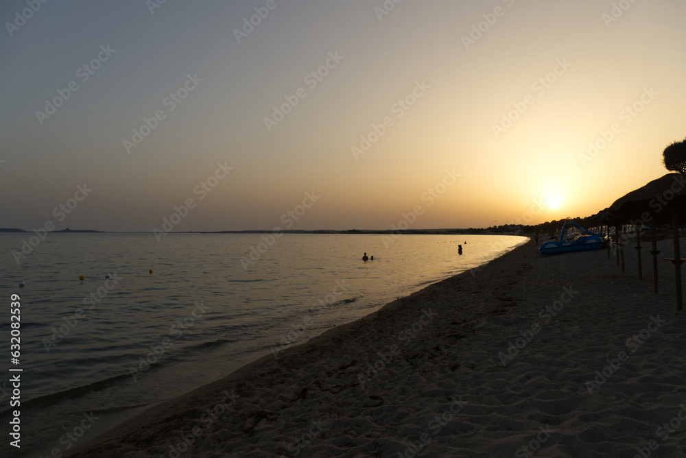 Calming sunset on a Sardinian beach with golden sea