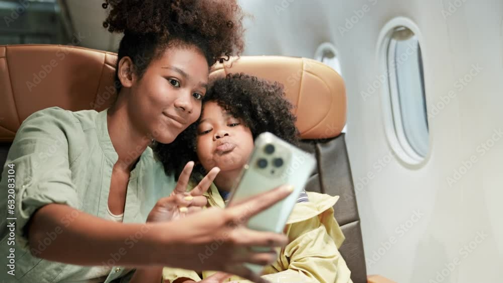 The girl was excited to get on a plane for the first time to travel. Child looks out window of an airplane in flight. Take a photo.Teenage flying in airplane. Talking while waiting to landing.