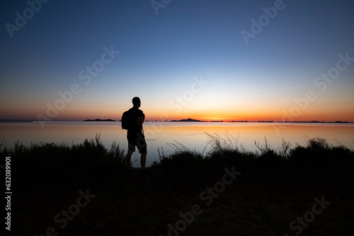 Silhouette of man hiking and contemplating the sunrise in the Mar Menor  Cartagena  Region of Murcia