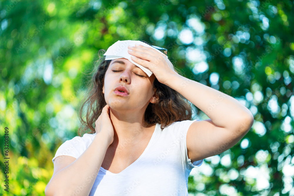 Young woman having hot flash and sweating in a warm summer day Young woman having hot flash and sweating in a warm summer day