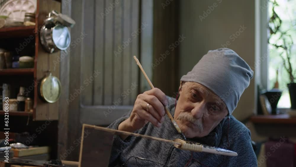 Elderly male master works in his restoring japanese deba knife
