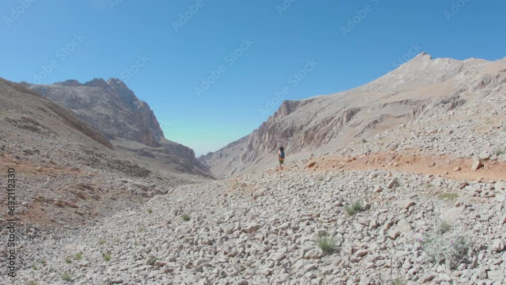 child travels in the mountains with a backpack. mountain hike in high mountains. the boy is walking along a mountain path. Turkey. child travels in the mountains with a backpack. mountain hike in high mountains. the boy is walking along a mountain path. Turkey.