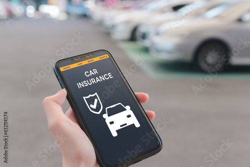 Hand using mobile phone device to access an online car insurance platform customers can compare quotes, With this innovative solution, file claims, and access roadside assistance right. photo