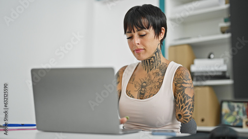 Hispanic woman with amputee arm business worker using laptop working at the office photo