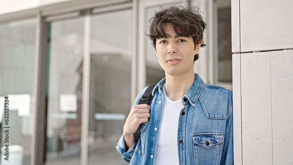 Young hispanic man student standing with relaxed expression at university