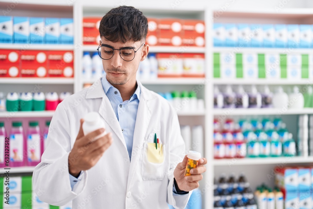 Young hispanic man pharmacist holding pills bottles at pharmacy