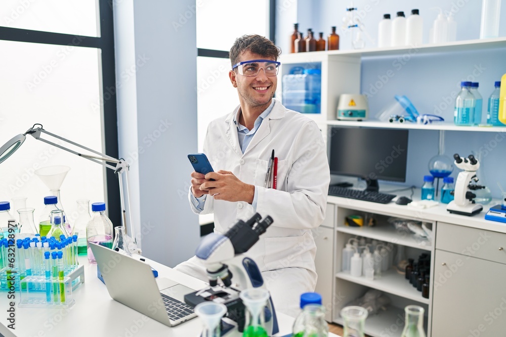 Young hispanic man scientist smiling confident using smartphone at laboratory Young hispanic man scientist smiling confident using smartphone at laboratory
