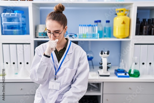 Young hispanic girl working at scientist laboratory feeling unwell and coughing as symptom for cold or bronchitis. health care concept.