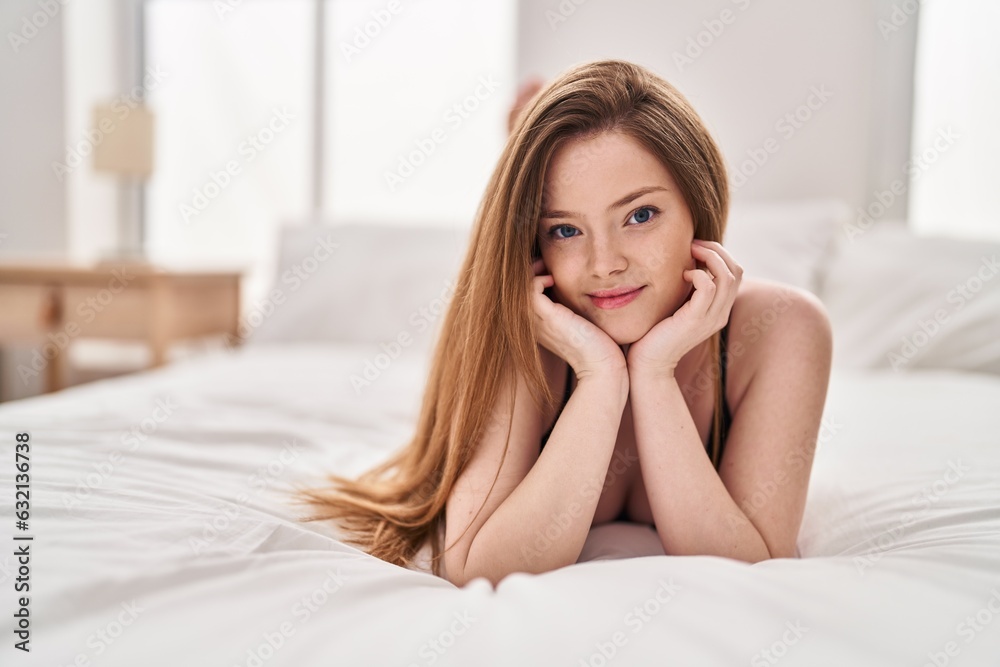Young caucasian woman smiling confident lying on bed at bedroom