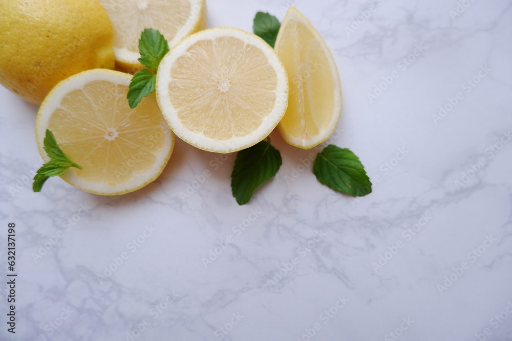 Fresh lemons composition on white marble background. Freshness and vitamin healthy fruits background. Slice lemons and fresh mint. Fresh lemons composition on white marble background. Freshness and vitamin healthy fruits background. Slice lemons and fresh mint.