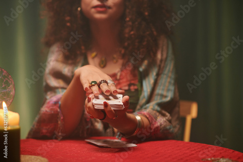 Canvas Print Hands of psychic shuffling tarot cards before spreading on table