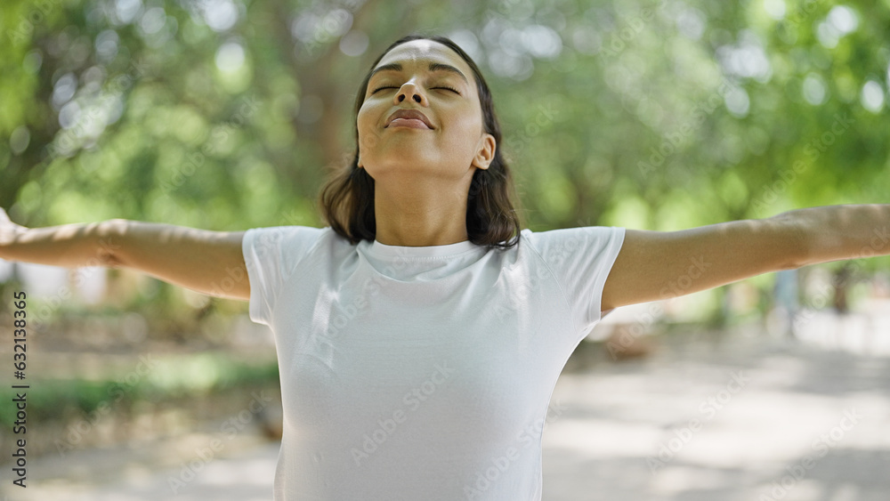 African american woman stretching arms breathing at park
