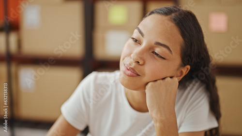 African american woman ecommerce business worker sitting on table thinking at office