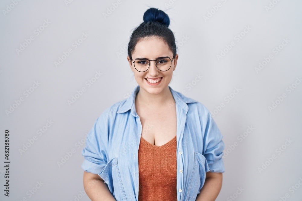 Young modern girl with blue hair standing over white background with a happy and cool smile on face. lucky person. Young modern girl with blue hair standing over white background with a happy and cool smile on face. lucky person.