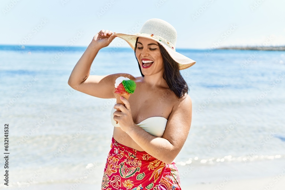 Young beautiful hispanic woman toruist smiling confident eating ice cream at seaside Young beautiful hispanic woman toruist smiling confident eating ice cream at seaside