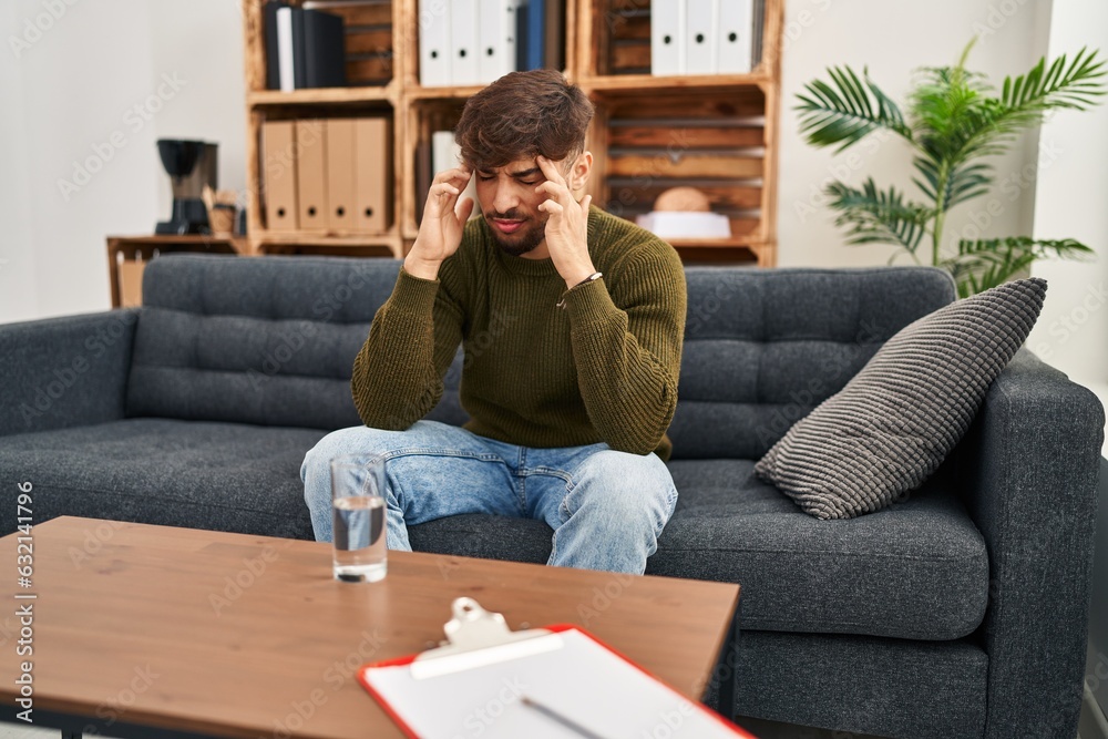 Arab man with beard working on depression at therapy office with hand on head, headache because stress. suffering migraine. Arab man with beard working on depression at therapy office with hand on head, headache because stress. suffering migraine.