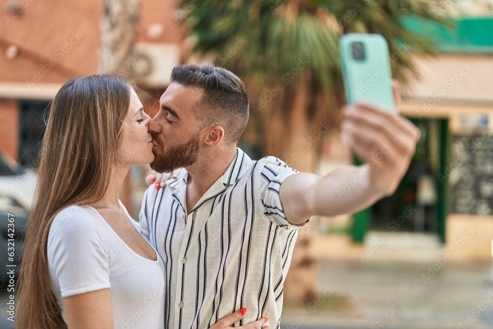 Man and woman couple make selfie by smartphone kissing at street